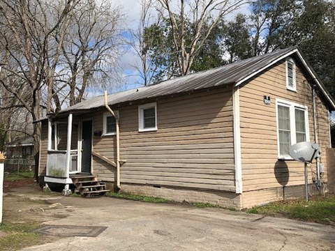 A small house with a porch and a mailbox on the right side.