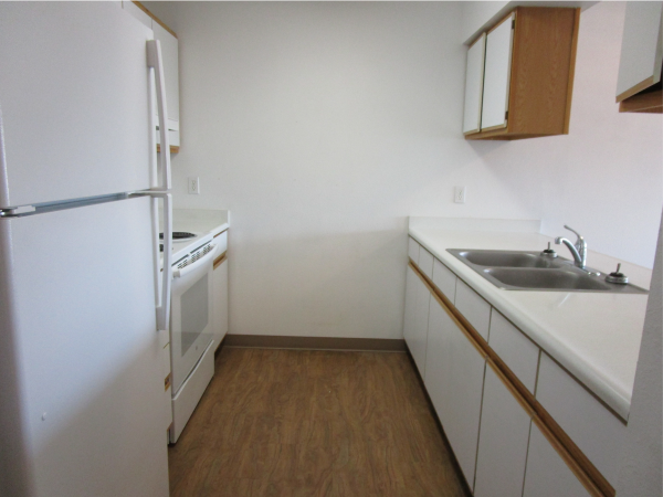 a kitchen with white cabinets and a sink and a refrigerator
