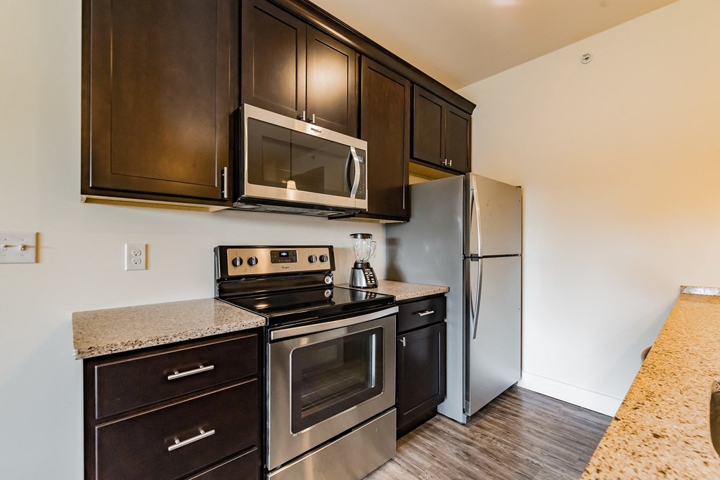 an updated kitchen with stainless steel appliances and dark wood cabinets