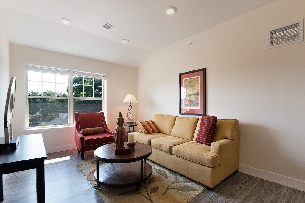 a living room with a couch and a chair and a window