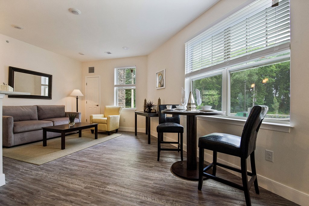 a living room with a couch and a desk and a large window