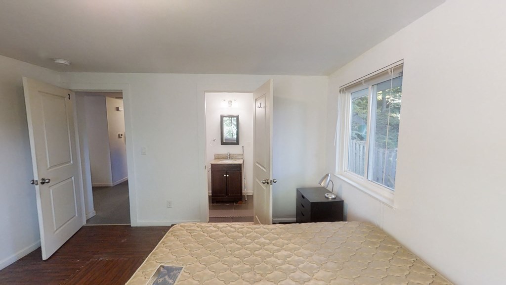 a bedroom with a bed and a bathroom with a sink