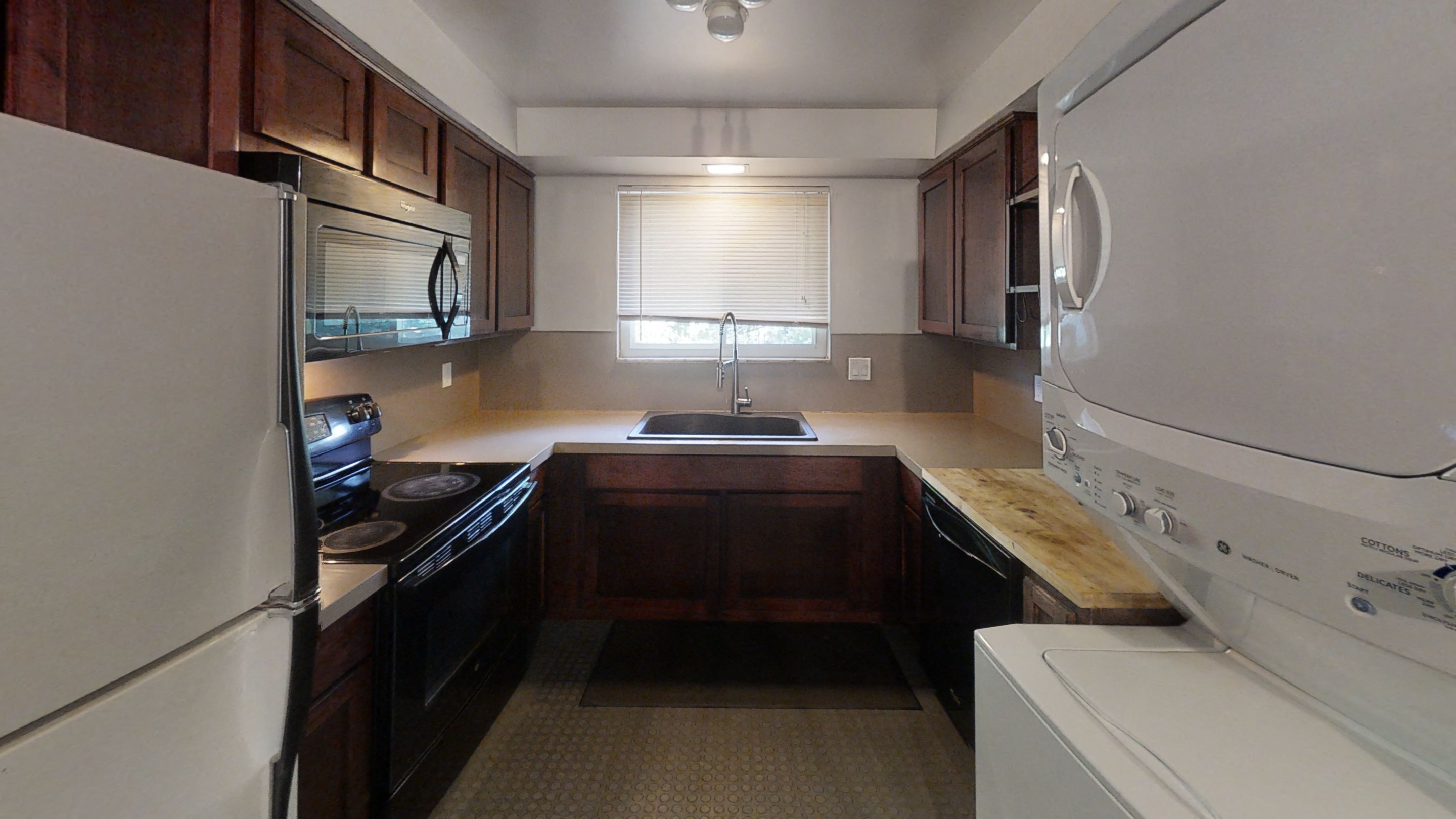 an empty kitchen with a washer and dryer in it