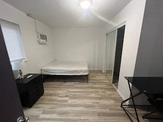 A bedroom with a bed, nightstand, and chair.