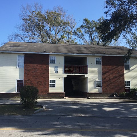 the front of a building with a porch and a balcony