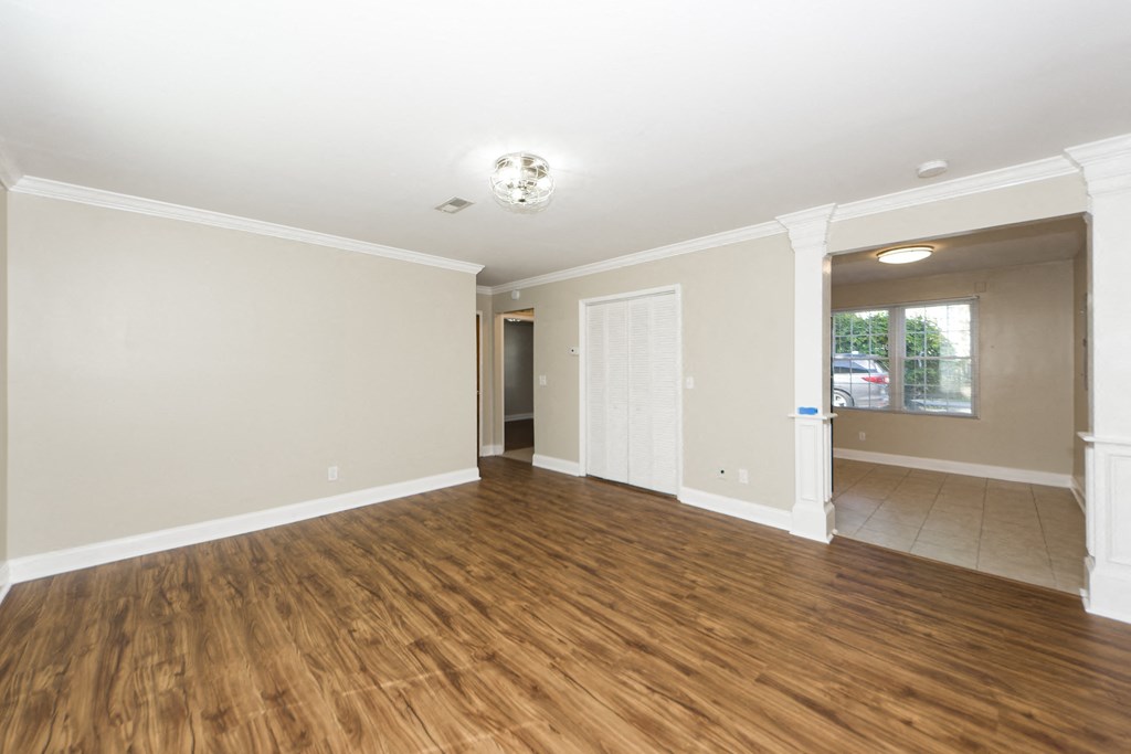 a living room with a hard wood floor and white walls