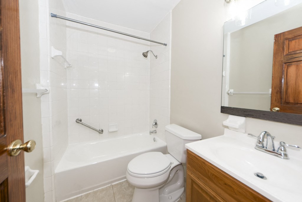 a bathroom with a toilet and a tub and a sink