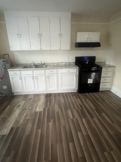 A kitchen with white cabinets and a black dishwasher.