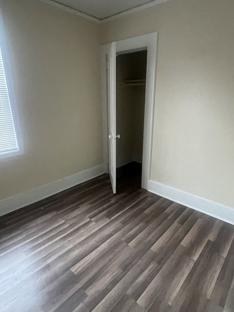 A room with a door and a wooden floor.