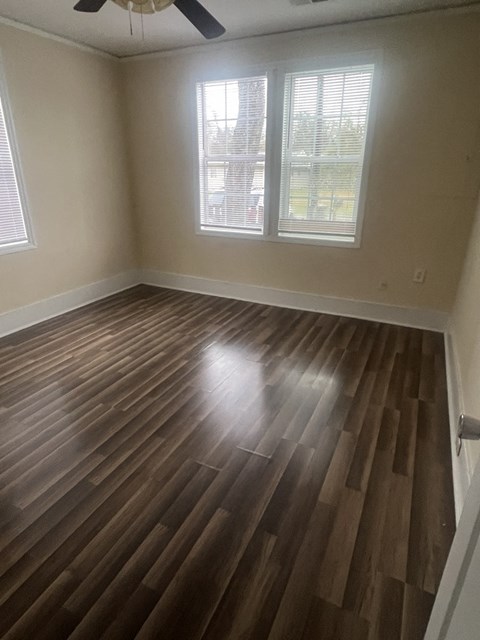 A room with a wooden floor and a ceiling fan.