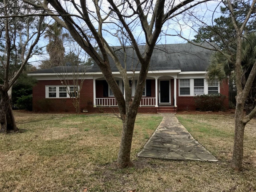 A red brick house with a white door and windows.