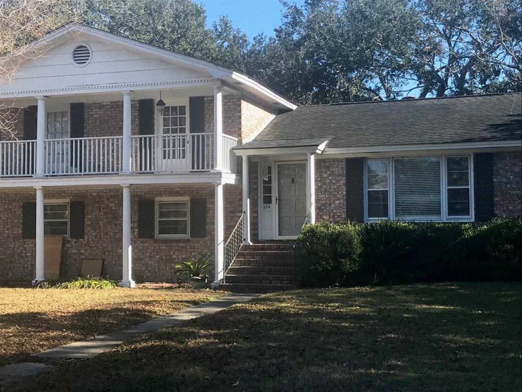 A house with a white porch and a brick facade.