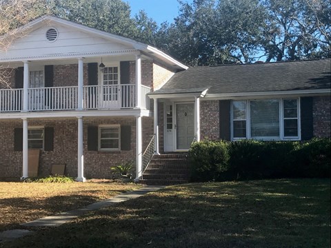 A house with a white porch and a brick facade.