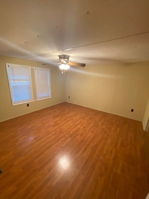 A room with wooden flooring and a ceiling fan.