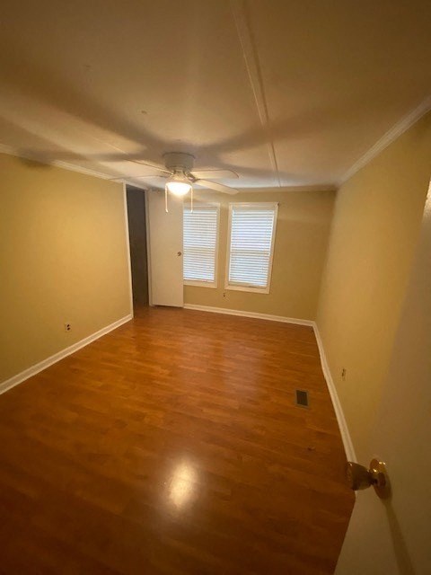 A room with wooden floors and a ceiling fan.