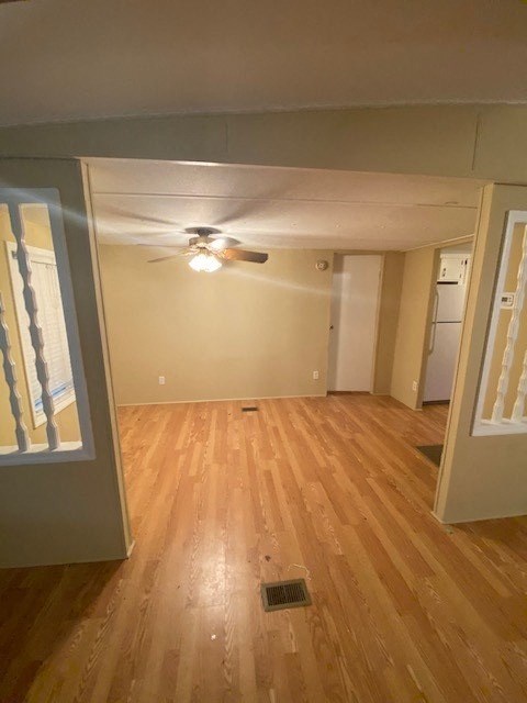 A room with wooden floors and a ceiling fan.