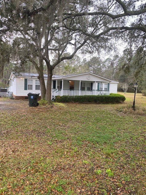 A house with a white picket fence and a tree in front of it.