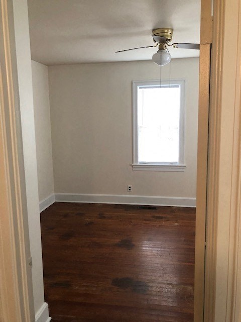 a empty room with a ceiling fan and a window
