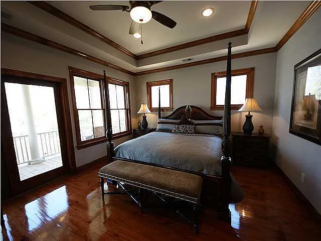A bedroom with a large bed and a ceiling fan.