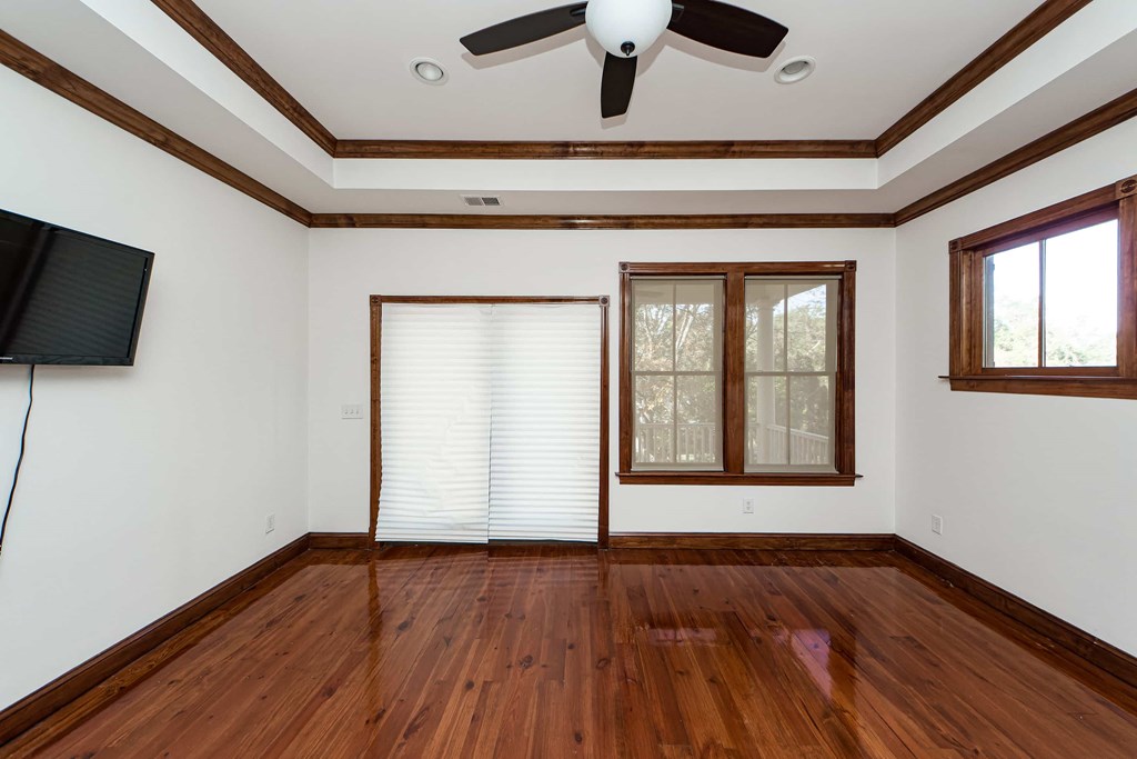 A room with wooden floors and a ceiling fan.