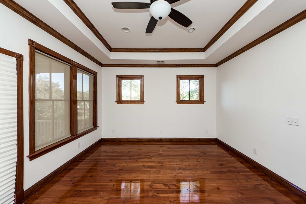 A room with wooden floors and a ceiling fan.
