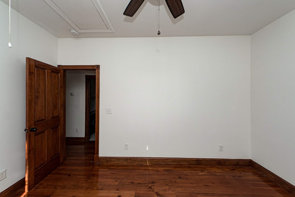 A room with a wooden floor and a ceiling fan.