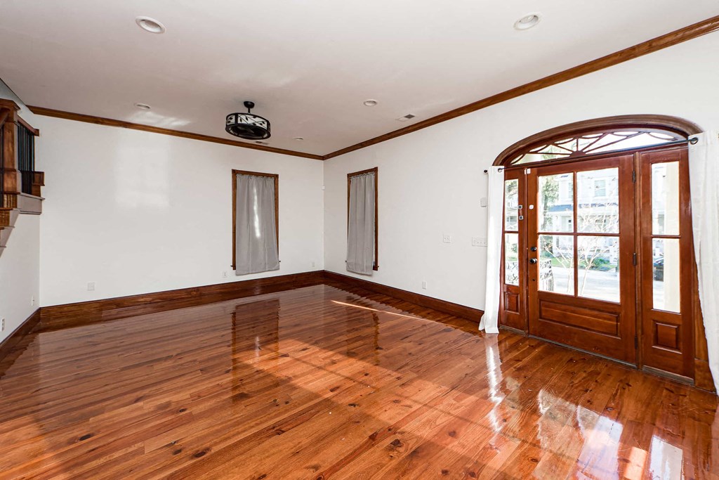 A room with wooden floors and a large arched doorway.