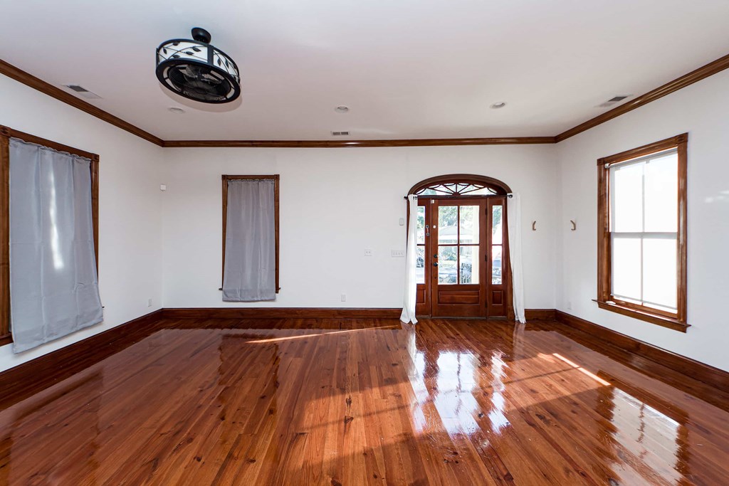 A room with wooden floors and a ceiling fan.