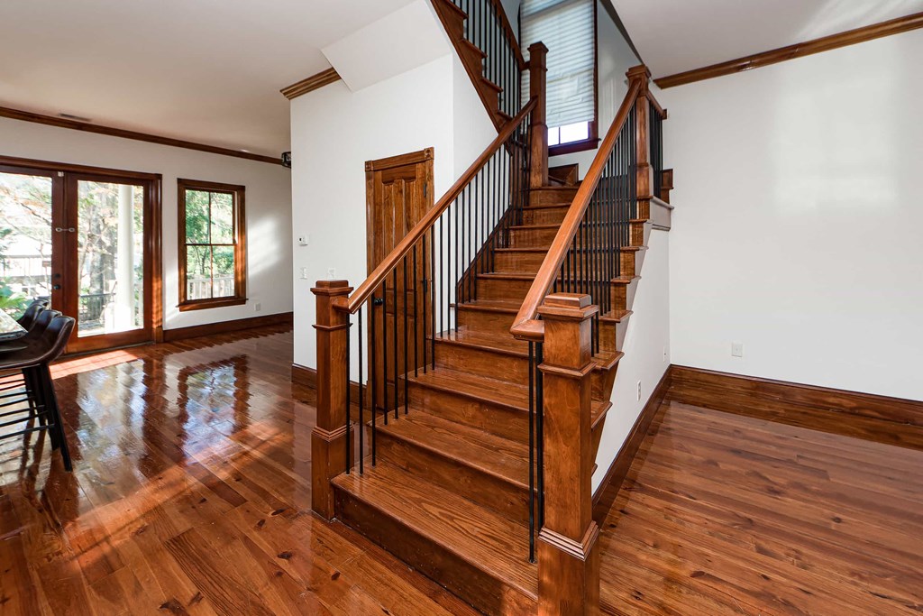 A wooden staircase with a black railing.