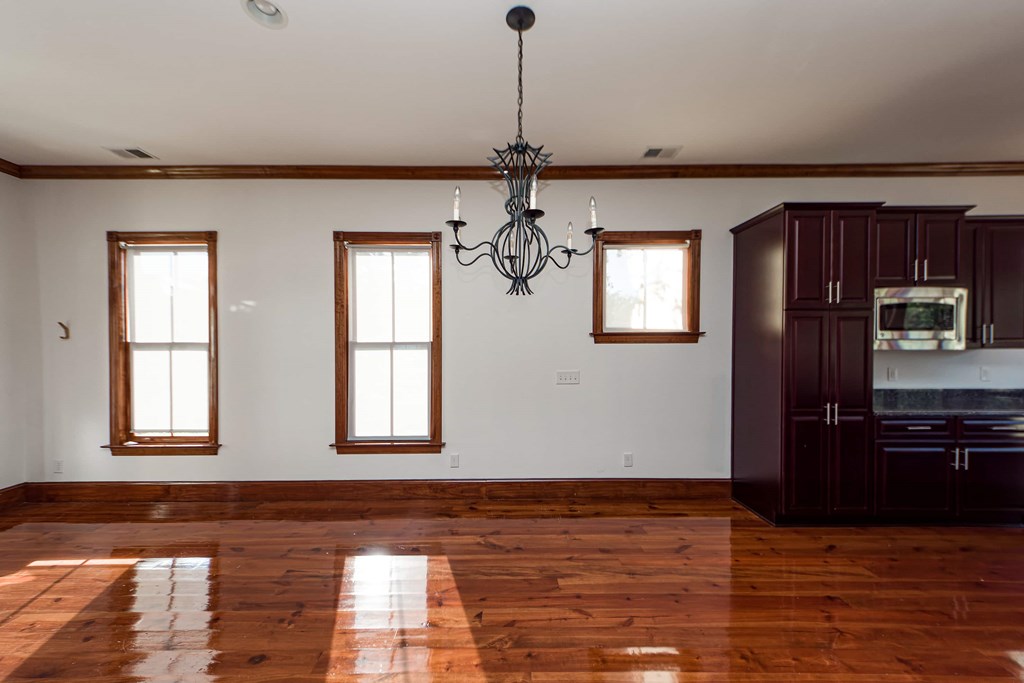 A large room with wooden floors and a chandelier.