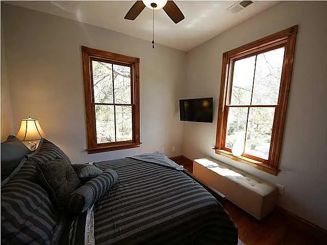 A bedroom with a bed, a window, and a ceiling fan.