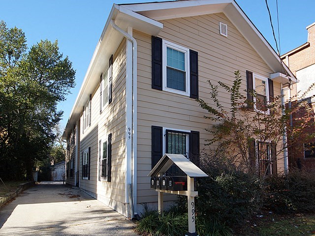 a white house with a sidewalk in front of it