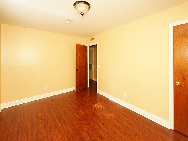 a empty room with a wooden floor and a door