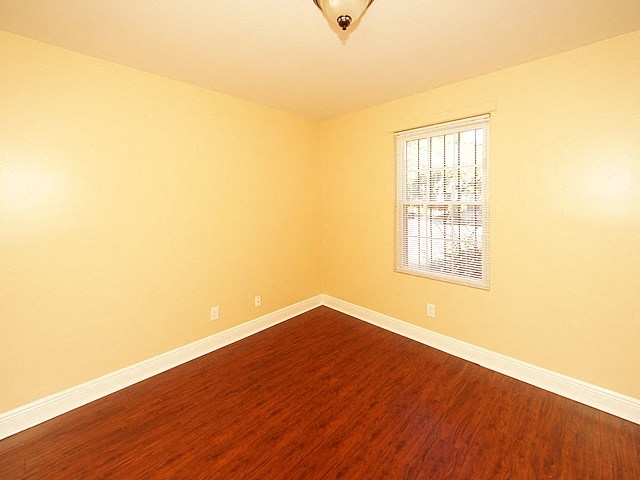 an empty room with wood floors and a window