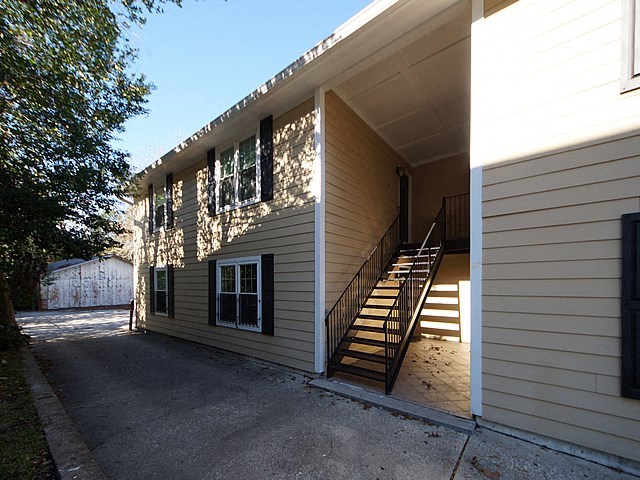 a white house with stairs and a driveway