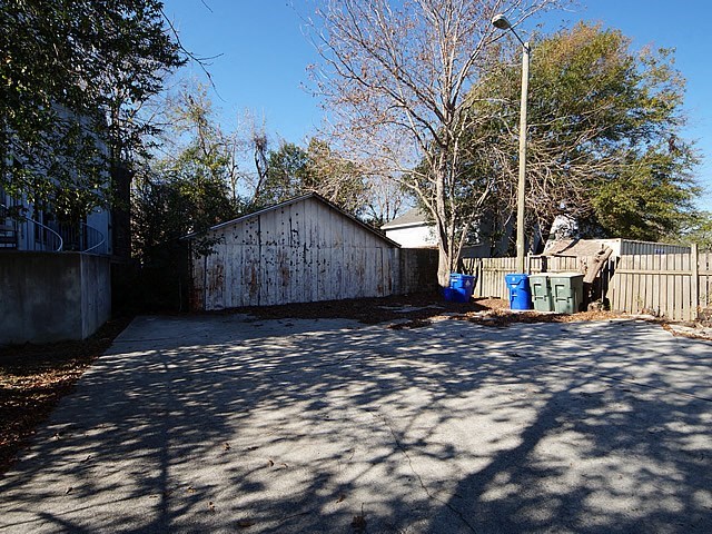 a small yard with a fence and a street