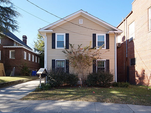a white house with a sidewalk in front of it