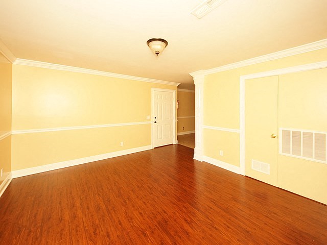 an empty room with a wood floor and a door