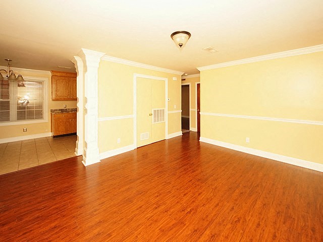 an empty living room with a hard wood floor