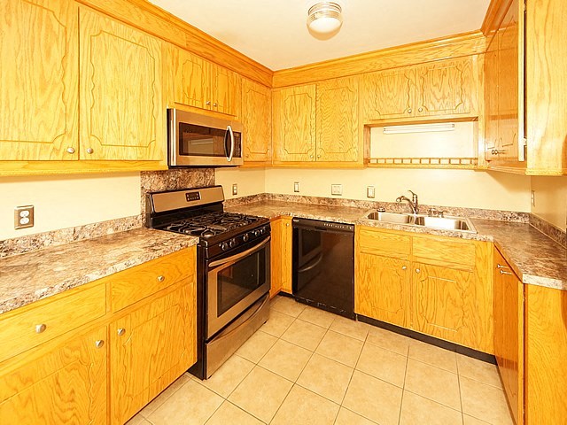 a kitchen with wooden cabinets and black appliances