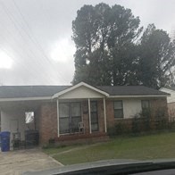 A house with a grey roof and a white garage door.