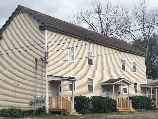 a yellow house with a brown roof