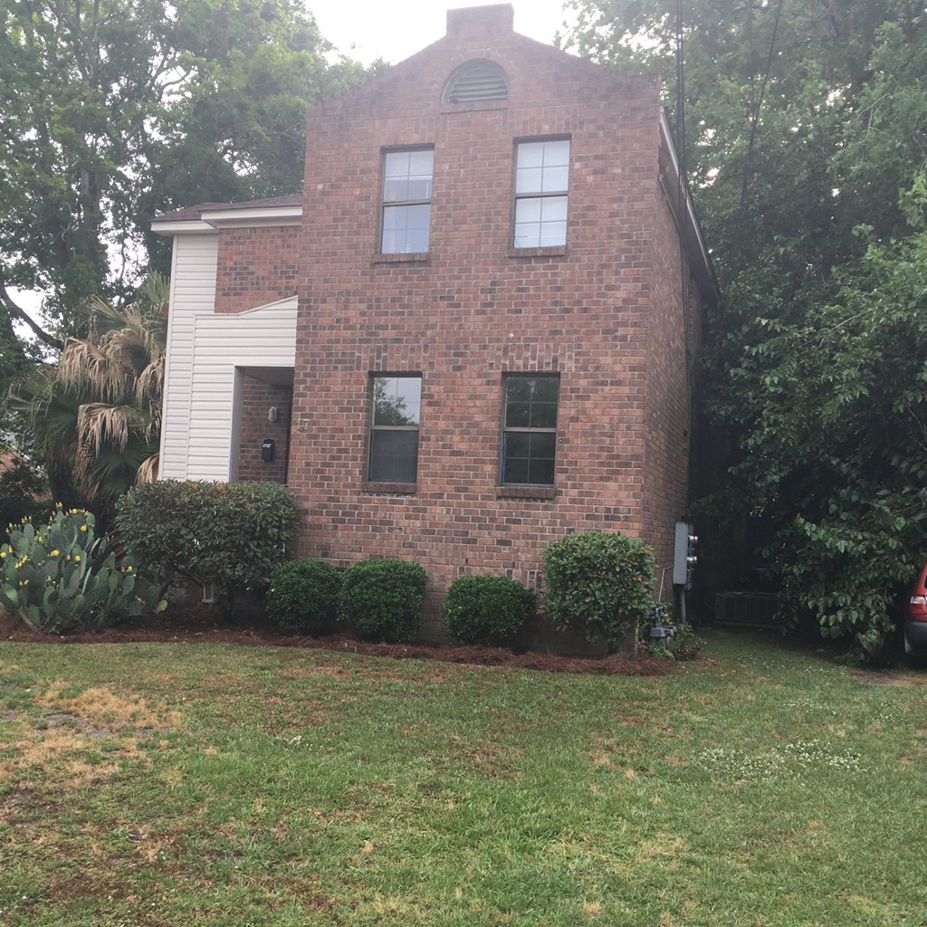 A red brick house with a white door and windows.