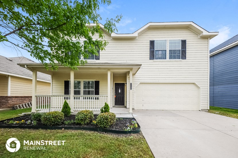 a white house with a white front porch and a driveway