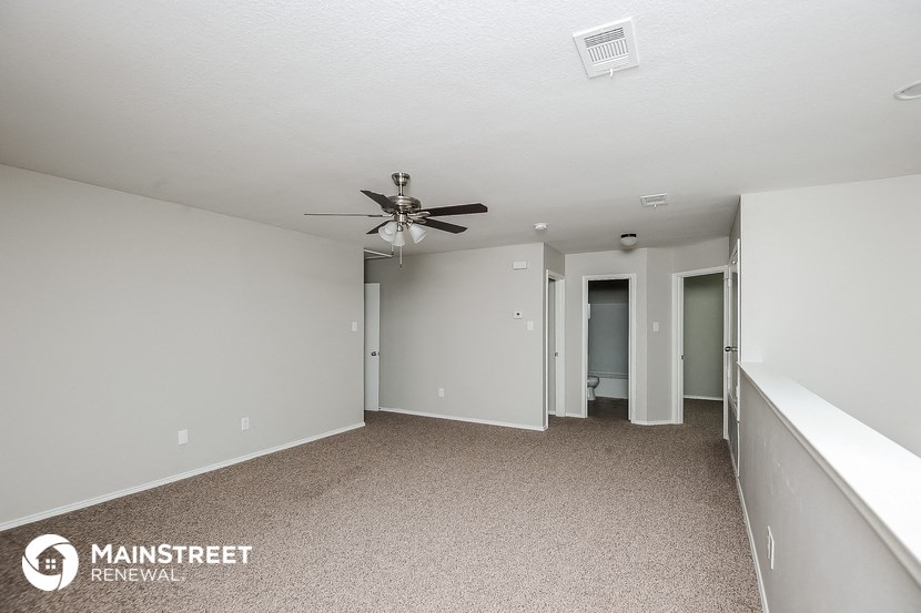 the living room of an apartment with a ceiling fan