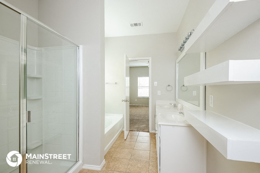 a white bathroom with a shower and a sink