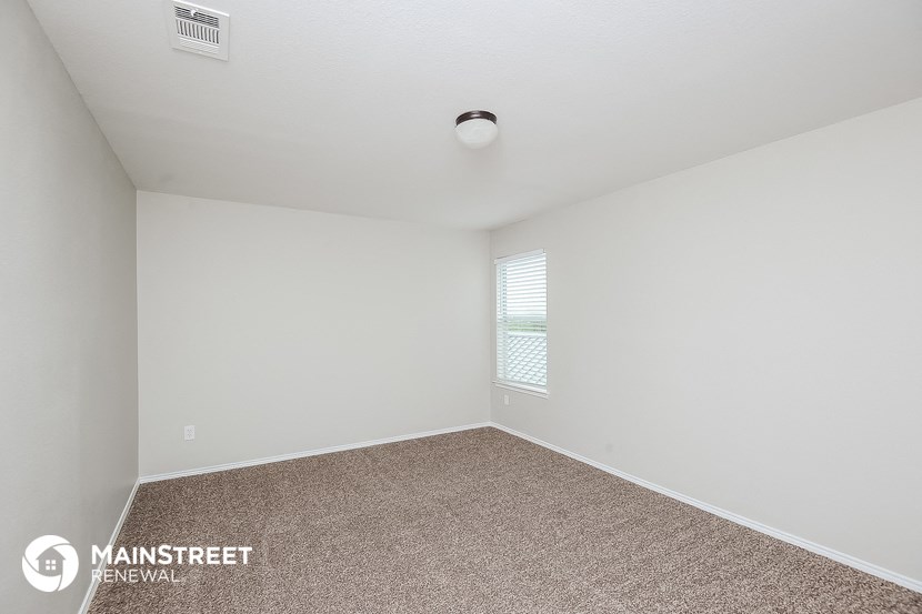 the spacious living room has carpeting and a window
