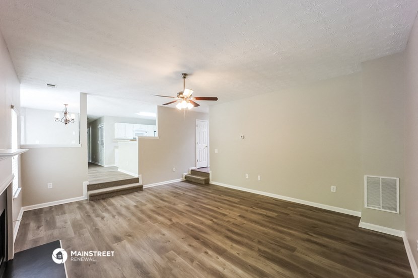 a living room with hardwood floors and a ceiling fan