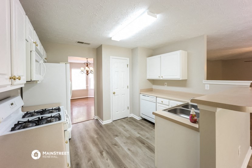 the view of a kitchen with white cabinets and a stove top oven