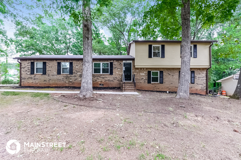 a small house with two trees in front of it
